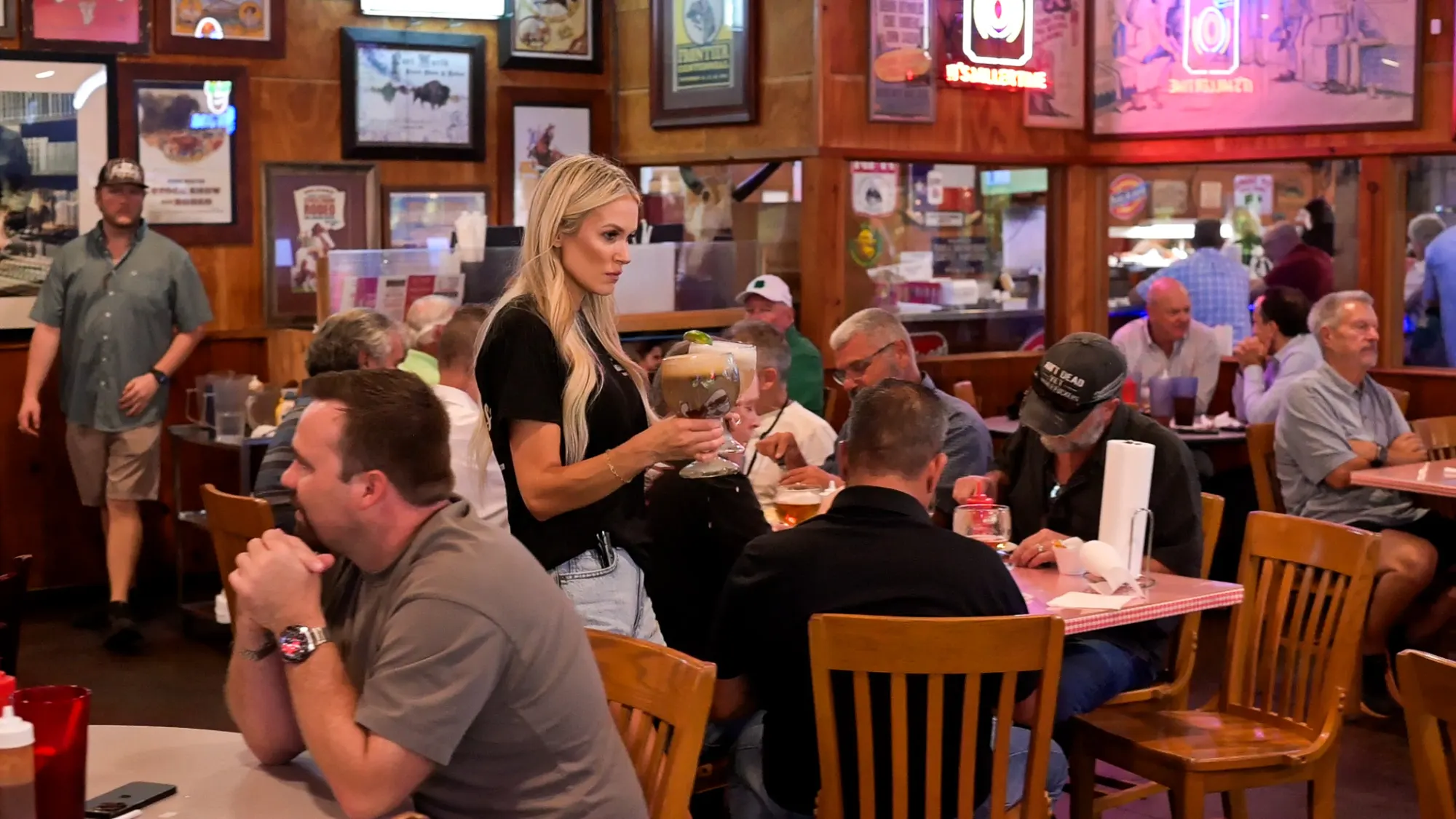 A server carrying drinks through the full dining room at Sammie's