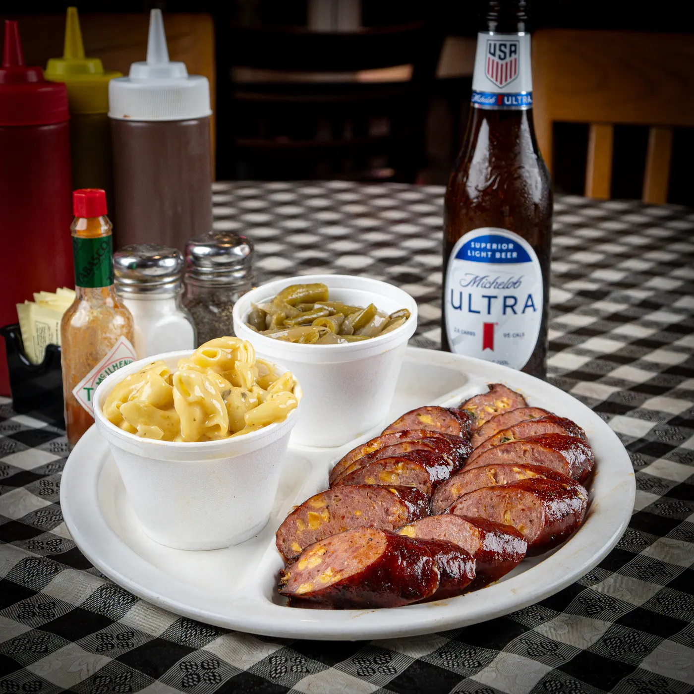 A one meat and two sides plate with sausage, mac and cheese and green beans