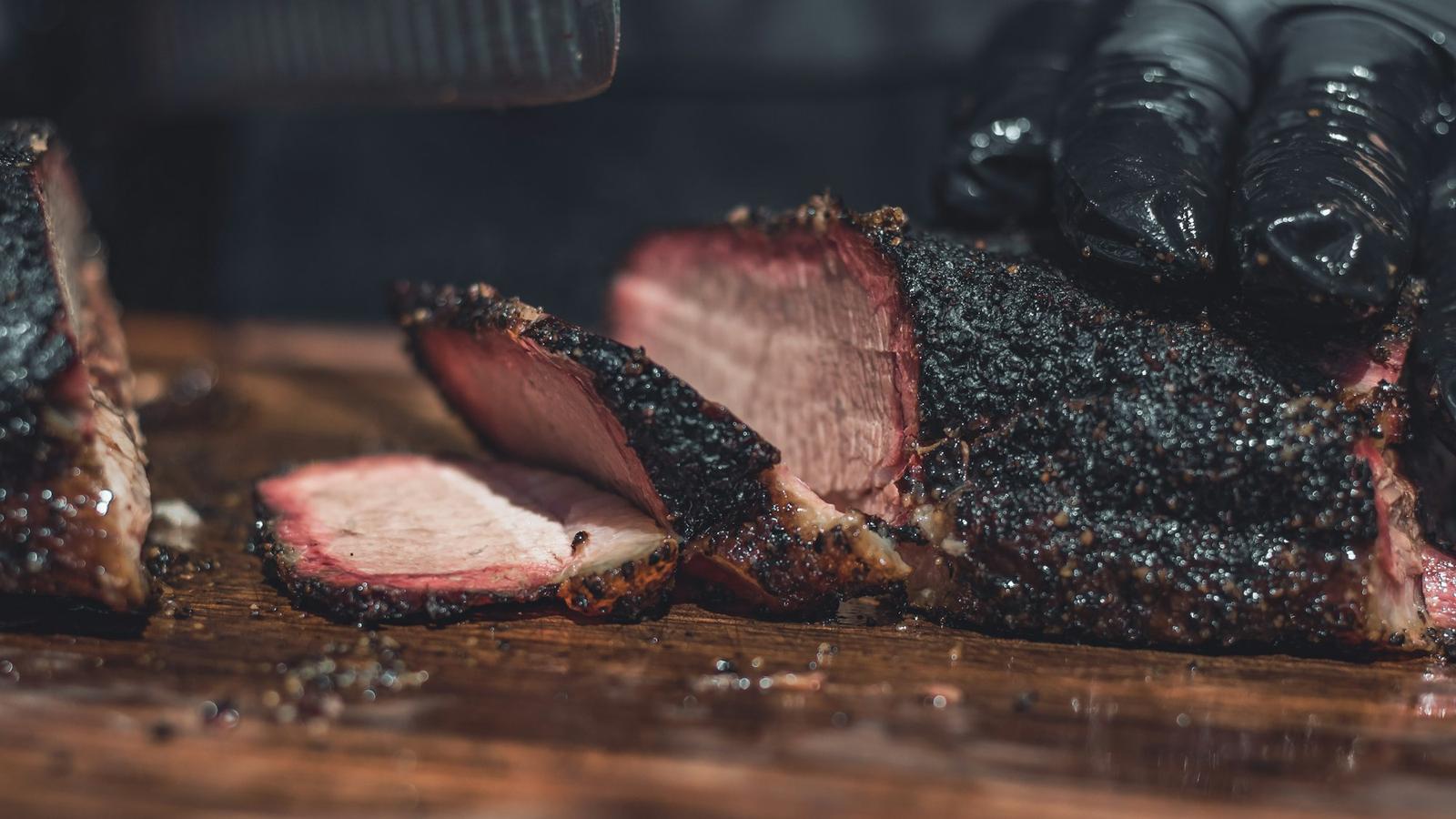 Sliced smoked brisket on wooden board