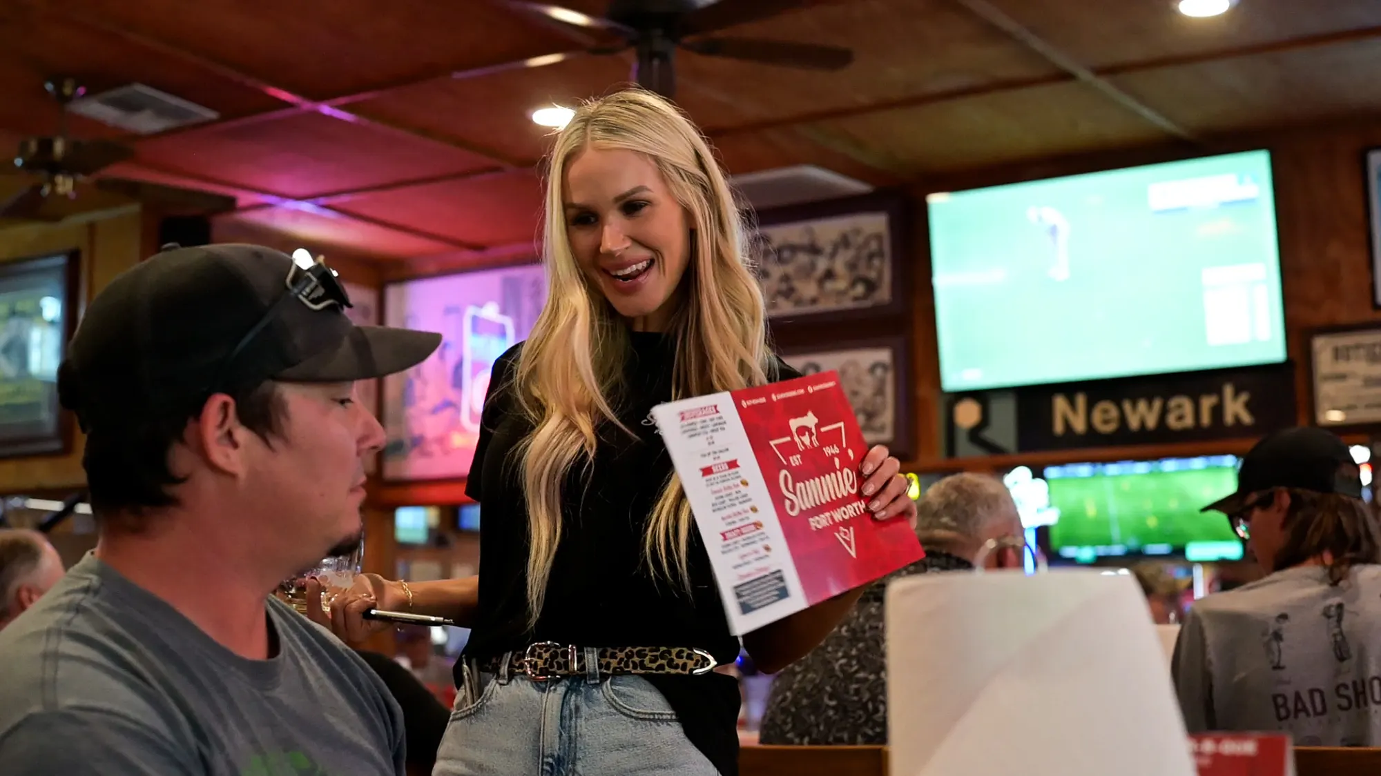 A Sammie's server showing the menu to guests in the dining room