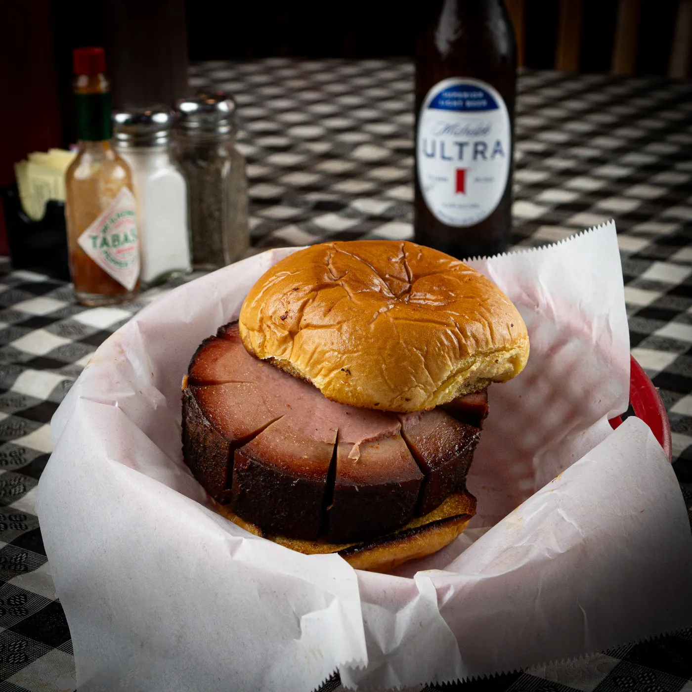 A thick-cut smoked bologna sandwich in a paper-lined basket
