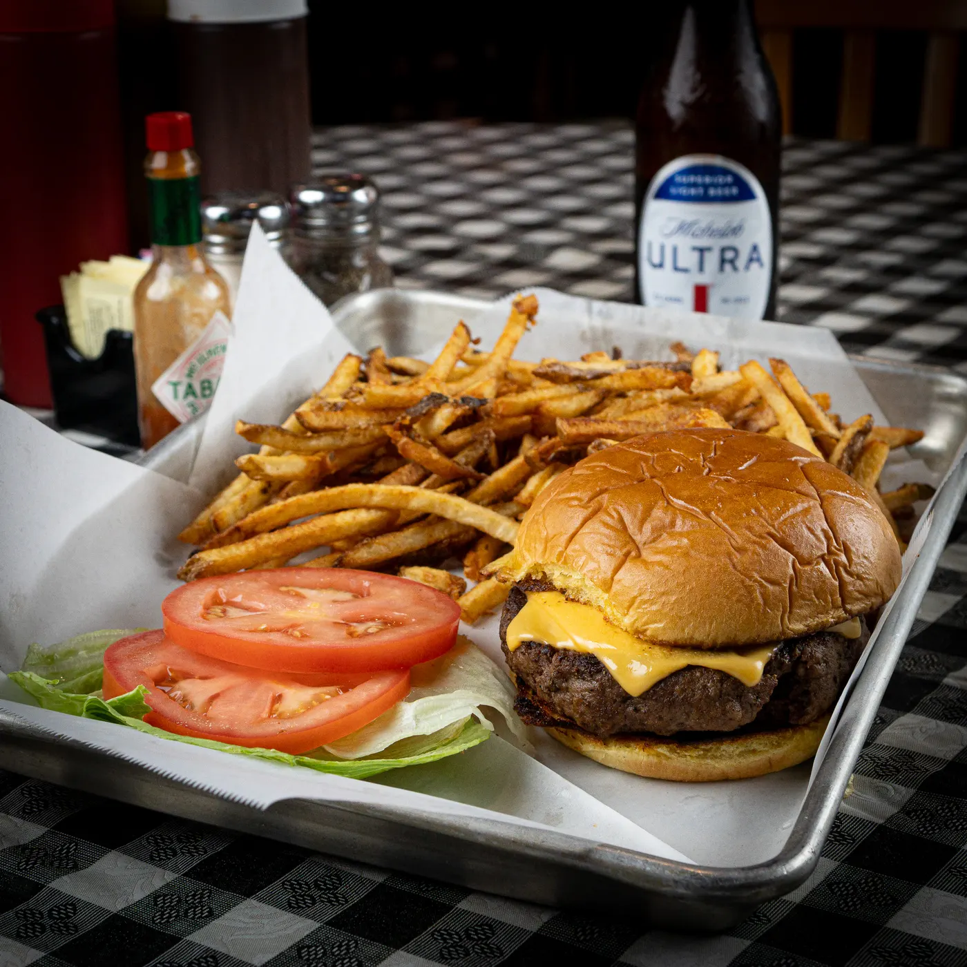 A burger with hand-cut french fries in a basket