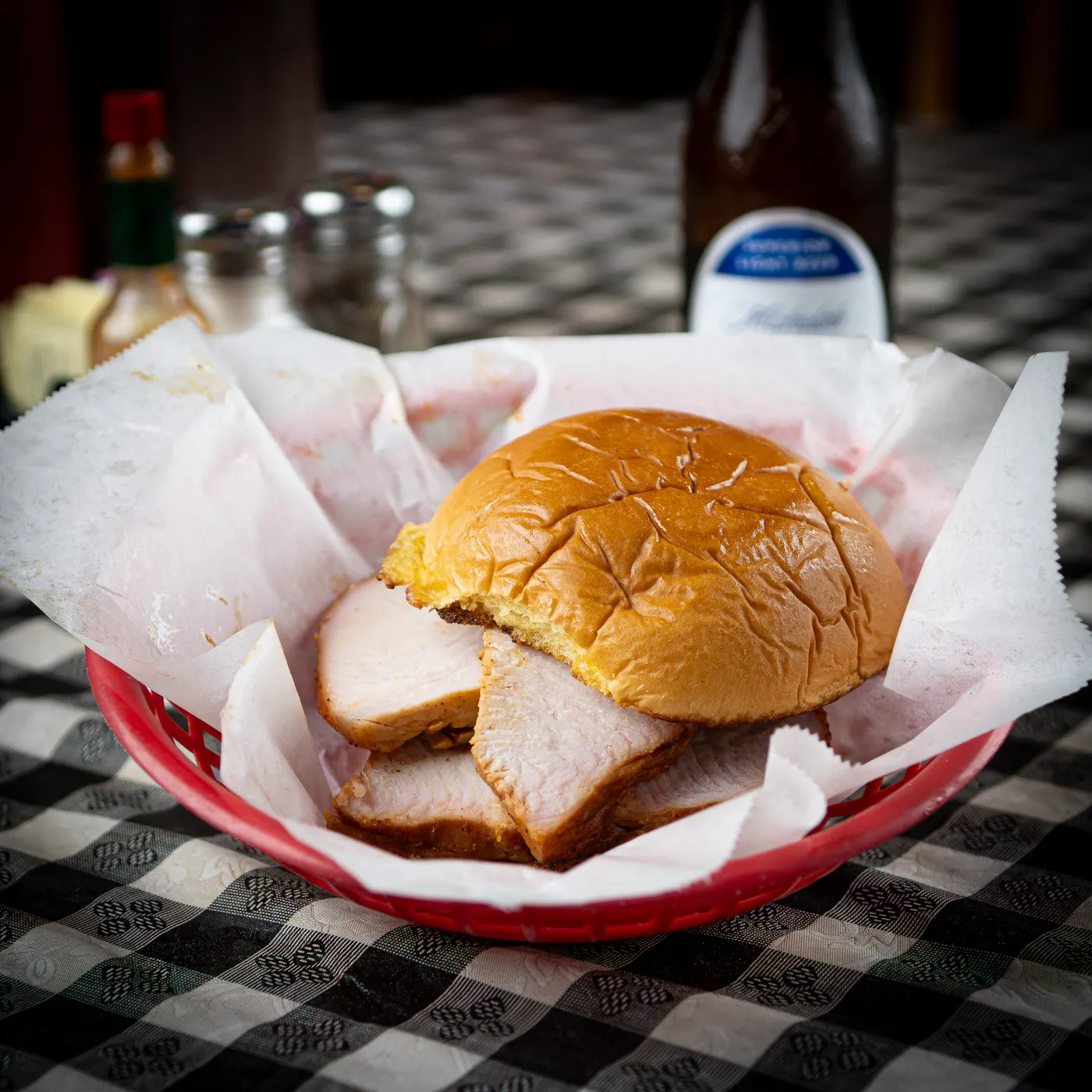 A smoked turkey sandwich in a paper-lined basket