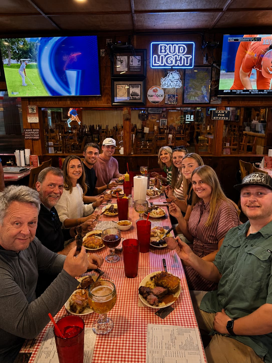 A full table of guests sharing a Sammies BBQ spread