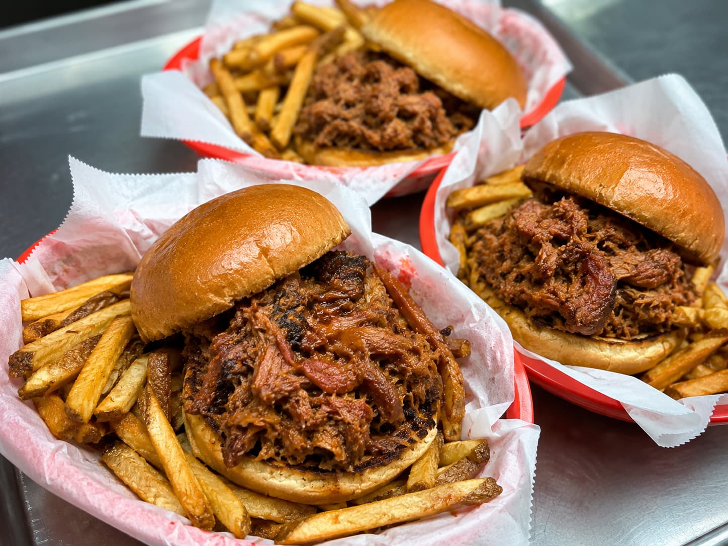 Pulled pork sandwiches with fries in red baskets