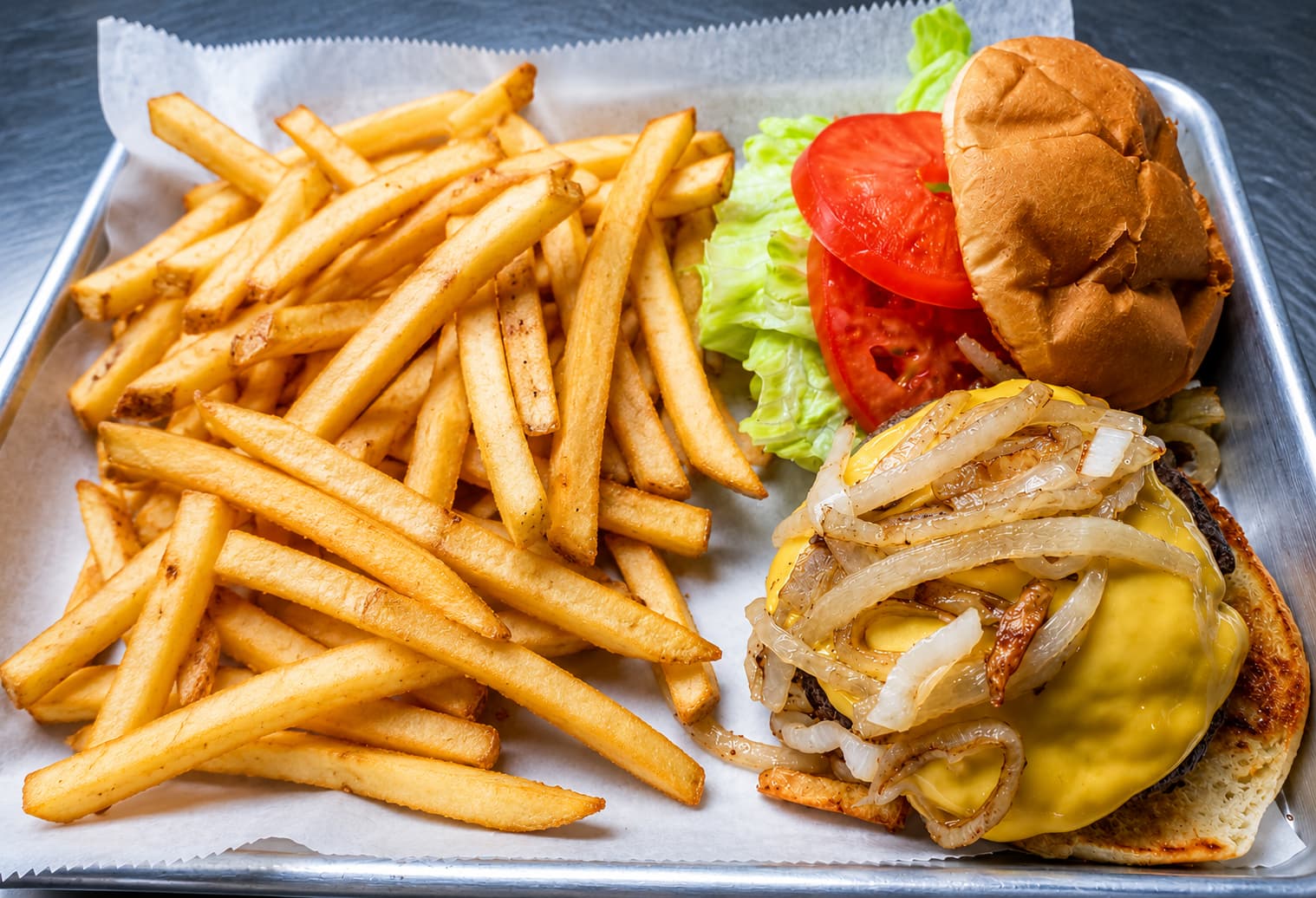 Smash burger with grilled onions and American cheese, with fries