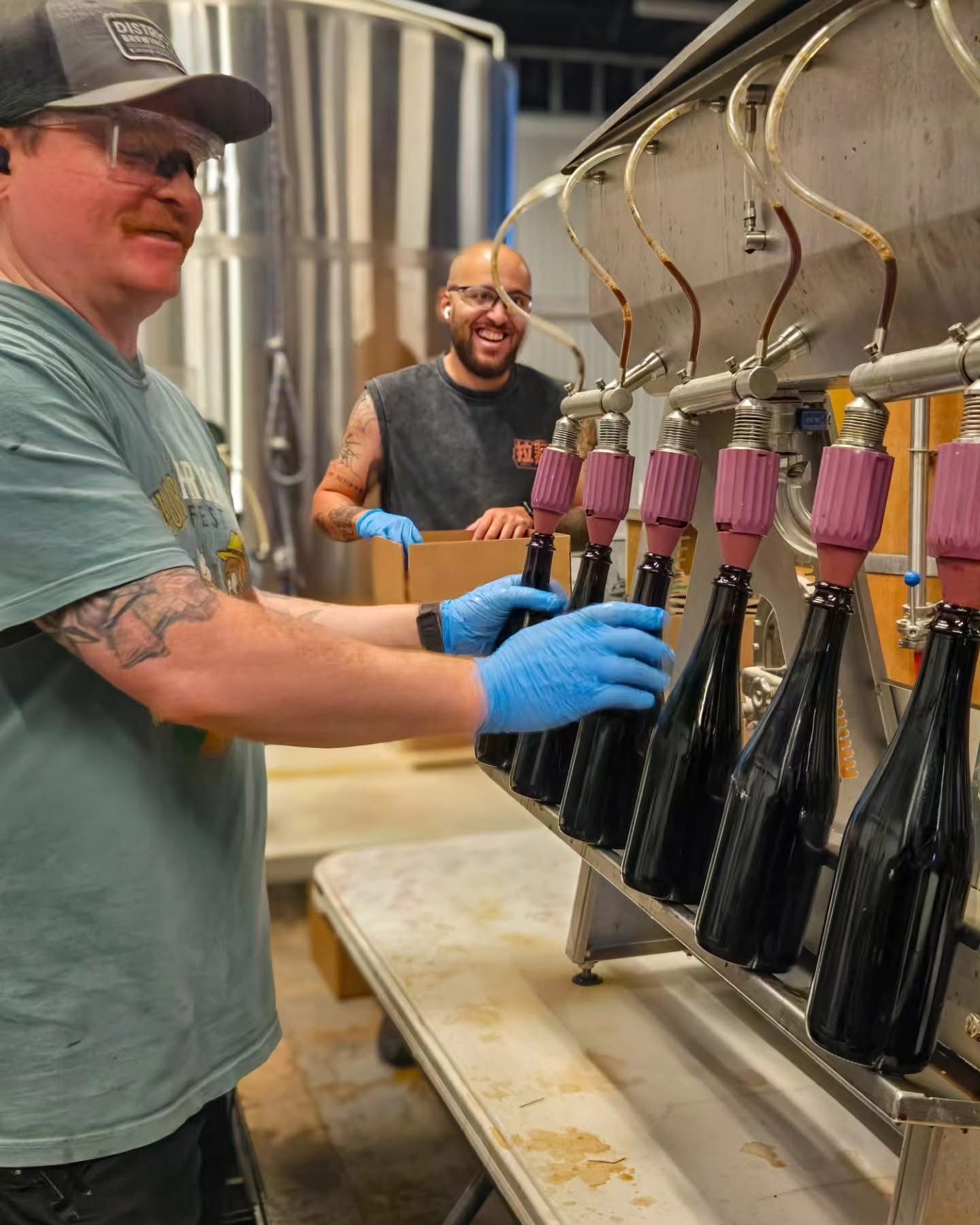 Two brewers filling bottles on the bottling line