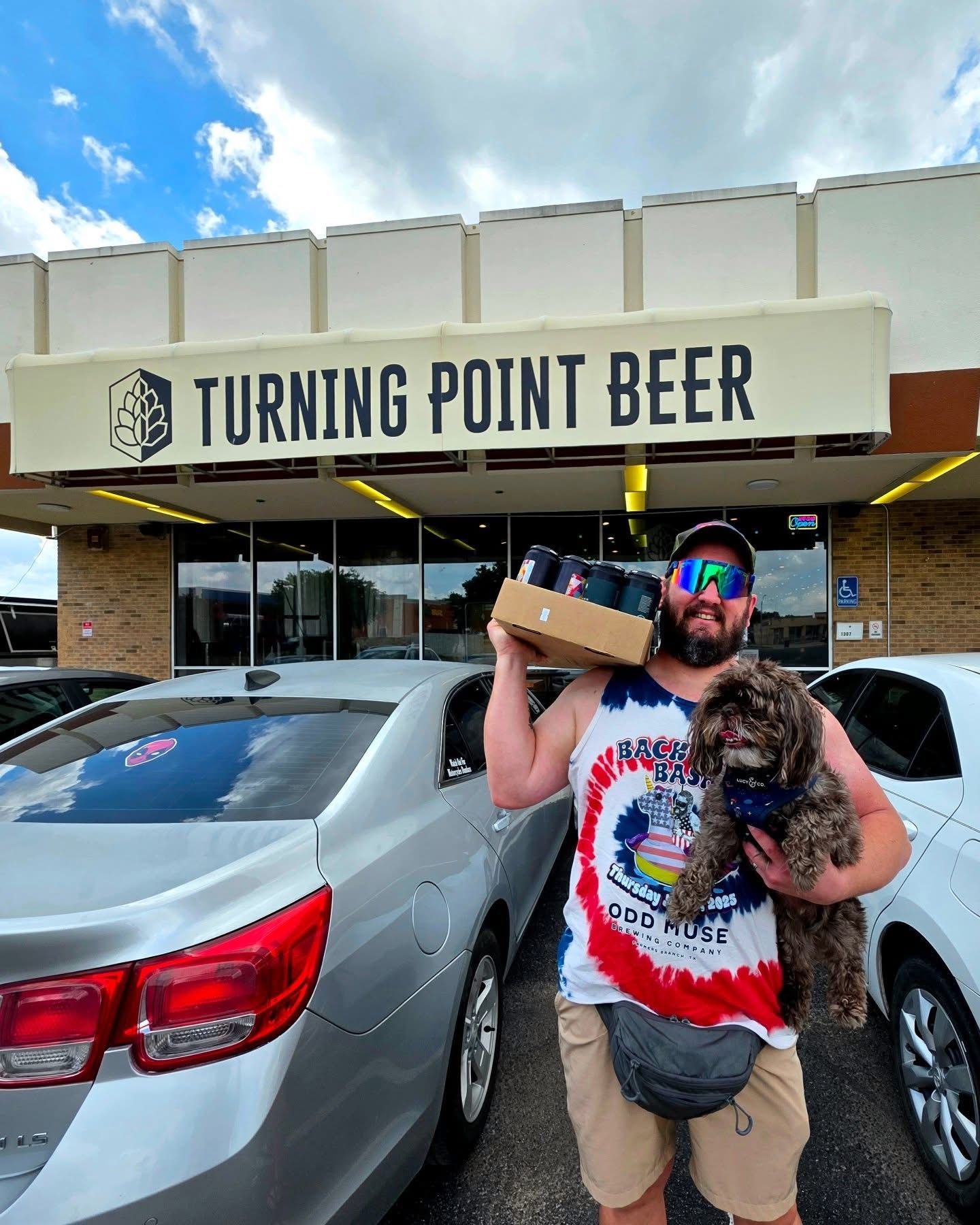 The Turning Point Beer storefront in Bedford with a regular carrying a four-pack and his dog